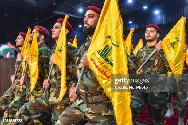 Supporters of the Shiite movement Hezbollah, wave party flags in Beirut's southern suburbs on April 14 as they gather to mark Al-Quds Day, a...