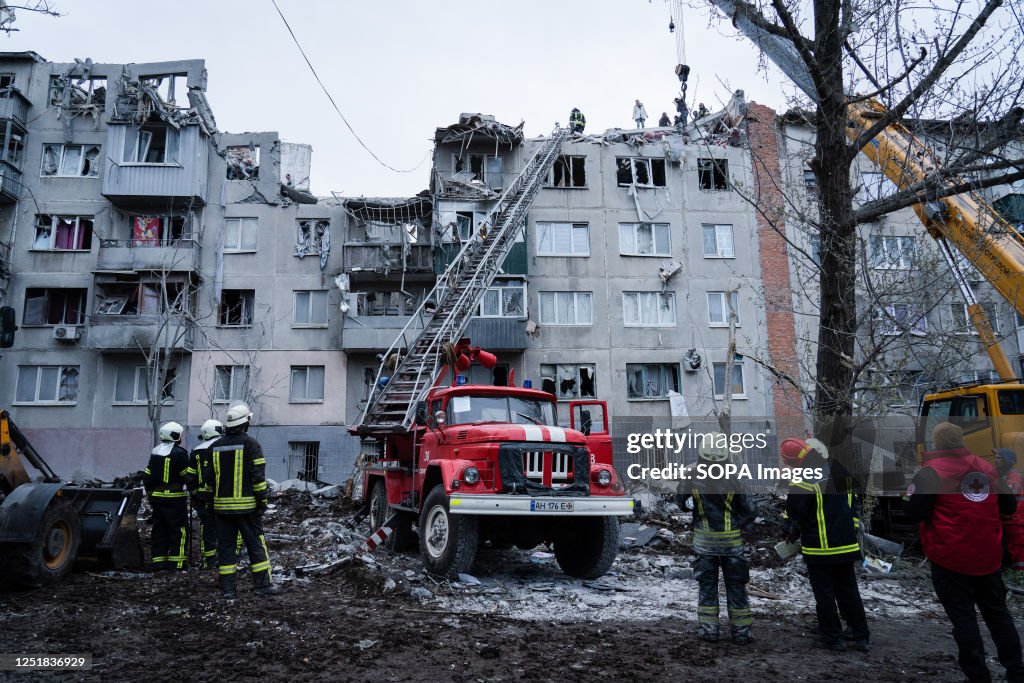 Firefighters and rescuers are seen searching for survivors...