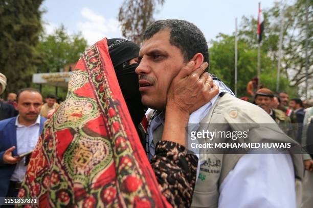 Woman hugs her son during a welcome ceremony for formerly-detained Yemeni Huthi rebels freed in a prisoner swap, upon arrival to the Sanaa airport on...