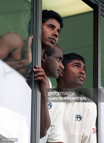 Sri Lankan players Chaminda Vaas, captain Sanath Jayasuriya and wicket keeper Romesh Kaluwitharana look into the skies as rain continued to disrupt...