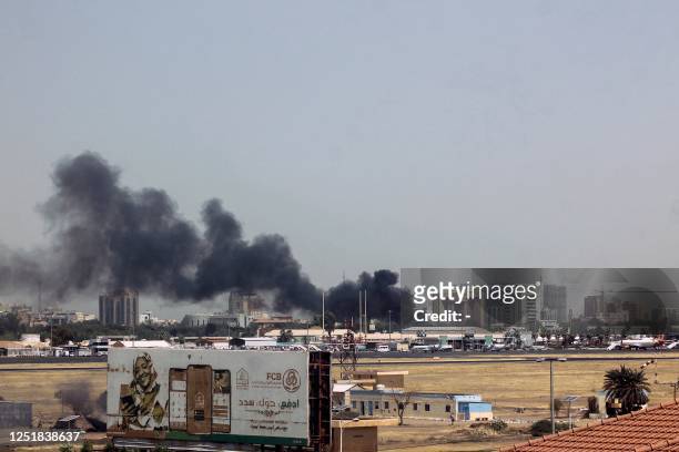 Heavy smoke billows above buildings in the vicinity of the Khartoum airport on April 15 amid clashes in the Sudanese capital. Explosions rocked the...