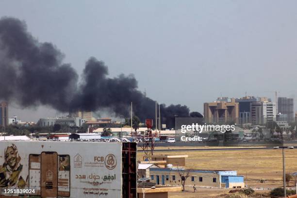 Heavy smoke billows above buildings in the vicinity of the Khartoum airport on April 15 amid clashes in the Sudanese capital. Explosions rocked the...