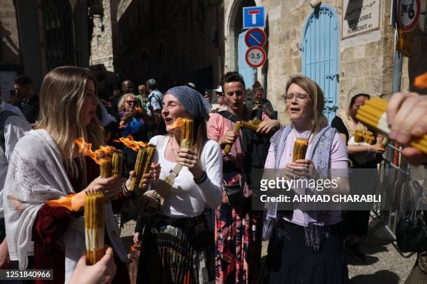 Christian worshippers carry candles lit with the 'Holy Fire' obtained from the Church of the Holy Sepulchre in Jerusalem, during the Orthodox...
