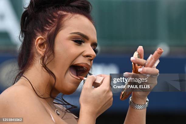 Racegoer puts make up on as she attends the final day of the Grand National Festival horse race meeting at Aintree Racecourse in Liverpool,...