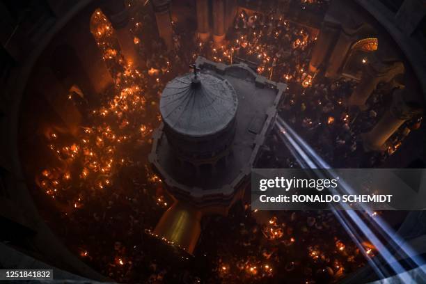 Beam on light enters Jerusalem's Holy Sepulchre as Orthodox Christians gather with lit candles around the Edicule, traditionally believed to be the...