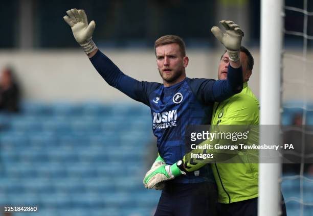 Millwall goalkeeper George Long being held by Millwall goalkeeper coach Andy Marshall during the warm up before the Sky Bet Championship match at The...