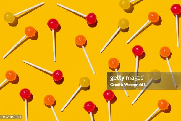 pattern of lollipops against yellow background - lollipop man stock-fotos und bilder