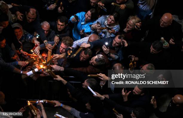 Orthodox Christians light their candles during the Holy Fire ceremony at the Holy Sepulchre church in Jerusalem's Old City on April 15, 2023 on the...