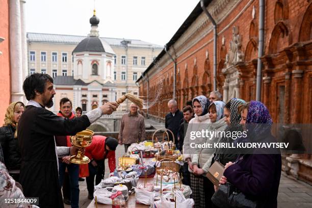 Russian Orthodox priest blesses Easter eggs and cakes in the yard of the Vysoko-Petrovsky Orthodox monastery in central Moscow on April 15 on the eve...