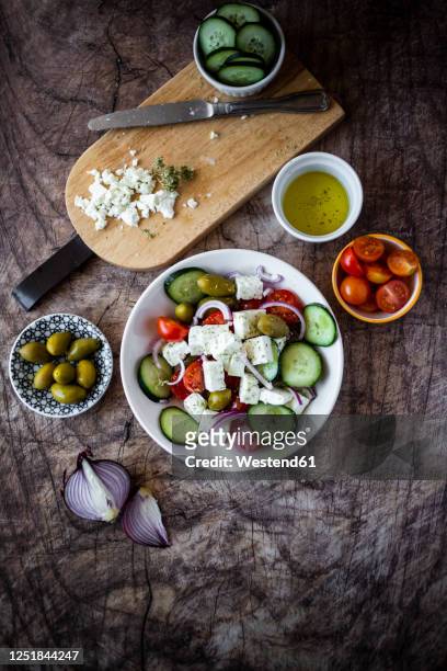 bowl of ready-to-eat greek salad and its ingredients - griechischer salat stock-fotos und bilder