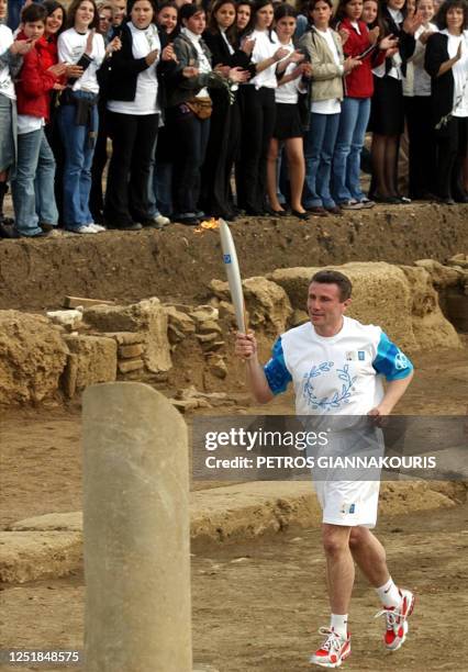 Ukranian pole vault legend Sergey Bubka runs with the Olympic flame toward the altar in ancient Ilida, March 25 a town near Ancient Olympia whose...