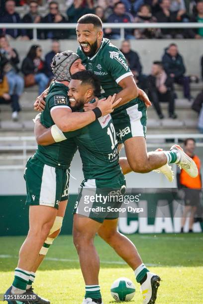 Beka GORGADZE of Section Paloise celebrates his try with Tumua MANU of Section Paloise and Zack HENRY of Section Paloise during the Top 14 match...