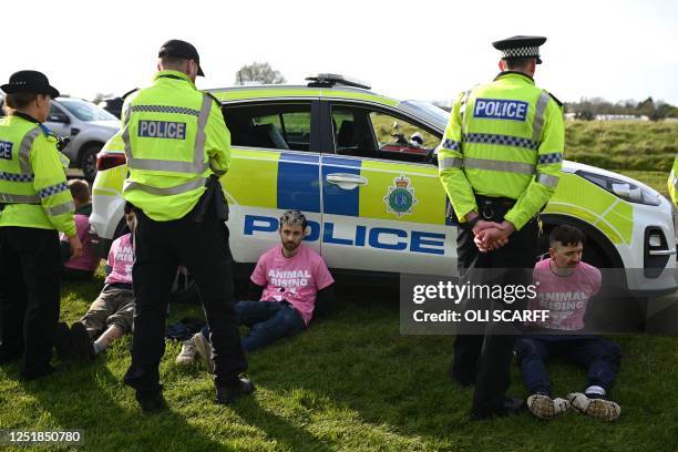 Animal rights protesters are apprehended by police officers ahead of the Grand National Handicap Steeple Chase on the final day of the Grand National...