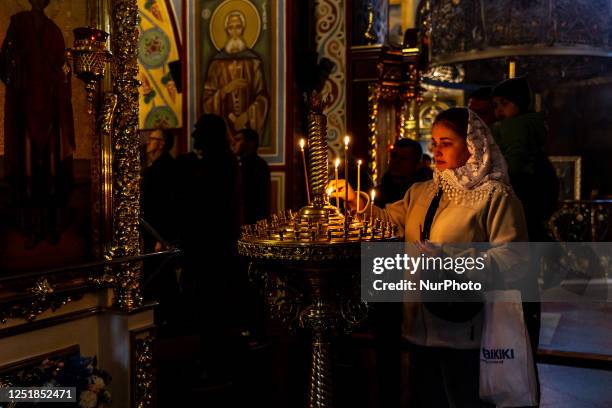 Ukrainian woman burns a candle during the Holy Saturday celebrations in St. Michael's Golden-Domed Monastery in Kyiv, the capital of Ukraine on...