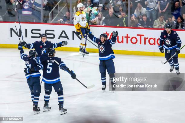 Neal Pionk of the Winnipeg Jets celebrates his goal with teammates Brenden Dillon, Nikolaj Ehlers, Vladislav Namestnikov, and Blake Wheeler during...