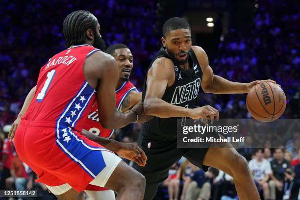 Mikal Bridges of the Brooklyn Nets dribbles the ball against James Harden and De'Anthony Melton of the Philadelphia 76ers in the fourth quarter...