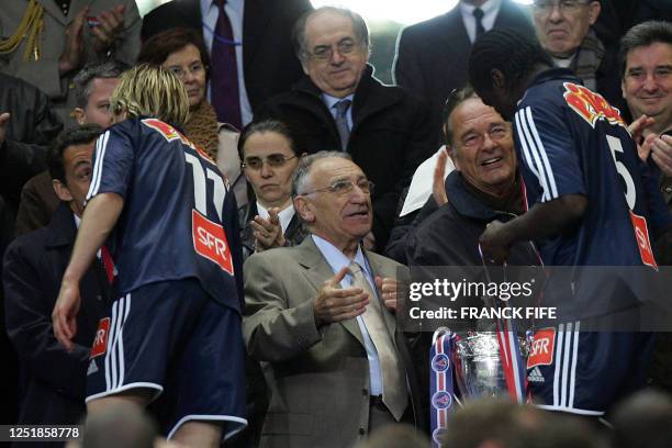 French president Jacques Chirac congratulates Paris' players next to French football federation president Jean-Pierre Escalettes after...