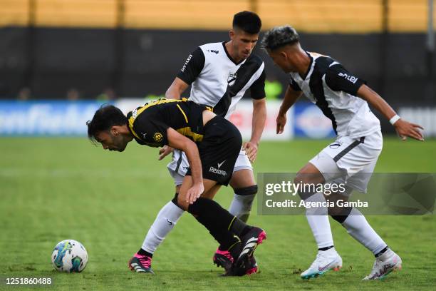 Sebastian Rodríguez of Peñarol fights for the ball with Martín Rea and Mateo Ponte of Danubio fight for the ball during a Torneo Apertura 2023 match...