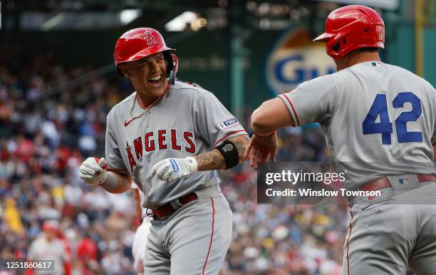 Gio Urshela of the Los Angeles Angels laughs as he is congratulated by Hunter Renfroe after his grand slam home run against the Boston Red Sox during...