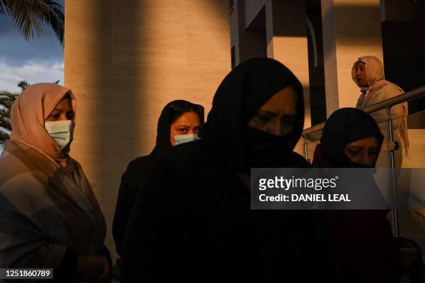 Women members of the Ahmadiyya Muslim Community arrive to attend a communal Iftar, the breaking of fast dinner, during the Islamic holy month of...