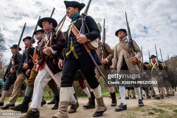 Hundreds of colonial militia reenactors march in formation during the Battle Road reenactment at Minute Man National Historical Park in Lincoln,...