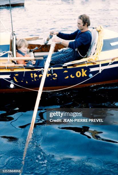 French oarsman Gérard d'Aboville arrives on September 21, 1980 aboard his rowing boat in Brest harbor, carrying his son in the boat. D'Aboville...