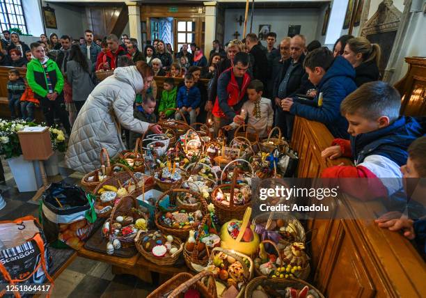 Devoted worshippers gather for the traditional Holy Saturday food basket blessing service at the Dormition of the Virgin Mary Greek Catholic parish,...