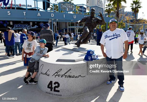 Fans pose in front of the Jackie Robinson statue prior to the start of the game between the Chicago Cubs and the Los Angeles Dodgers at Dodger...