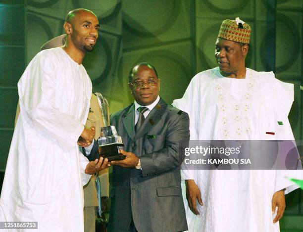 Malian footballer and signing for Sevilla FC Frederic Kanoute shakes hand with Togo's prime minister Komlan Mally as Africa's soccer governing body...