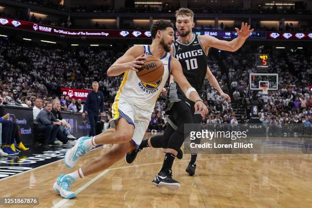Klay Thompson of the Golden State Warriors drives to the basket as Domantas Sabonis of the Sacramento Kings defends during the fourth quarter in Game...