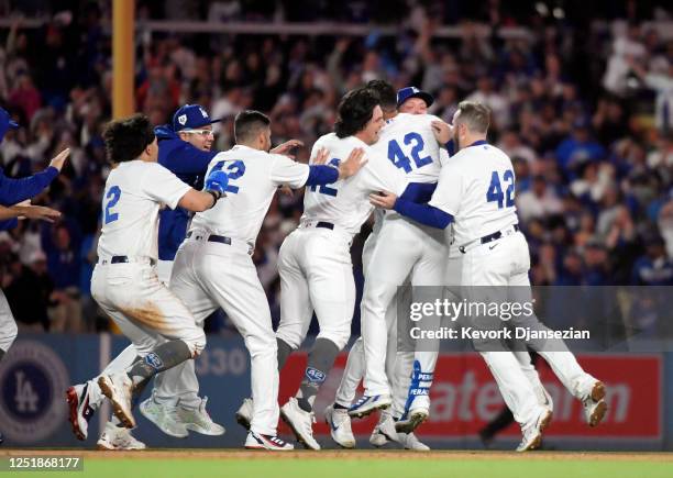 David Peralta of the Los Angeles Dodgers is mobbed by his teammates after hitting the game-winning walk-off two-run base hit to defeat the Chicago...