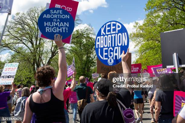 Activists holding abortion rights signs and shout slogans while joining in a rally. Abortion rights activists rallied outside the US Supreme Court in...