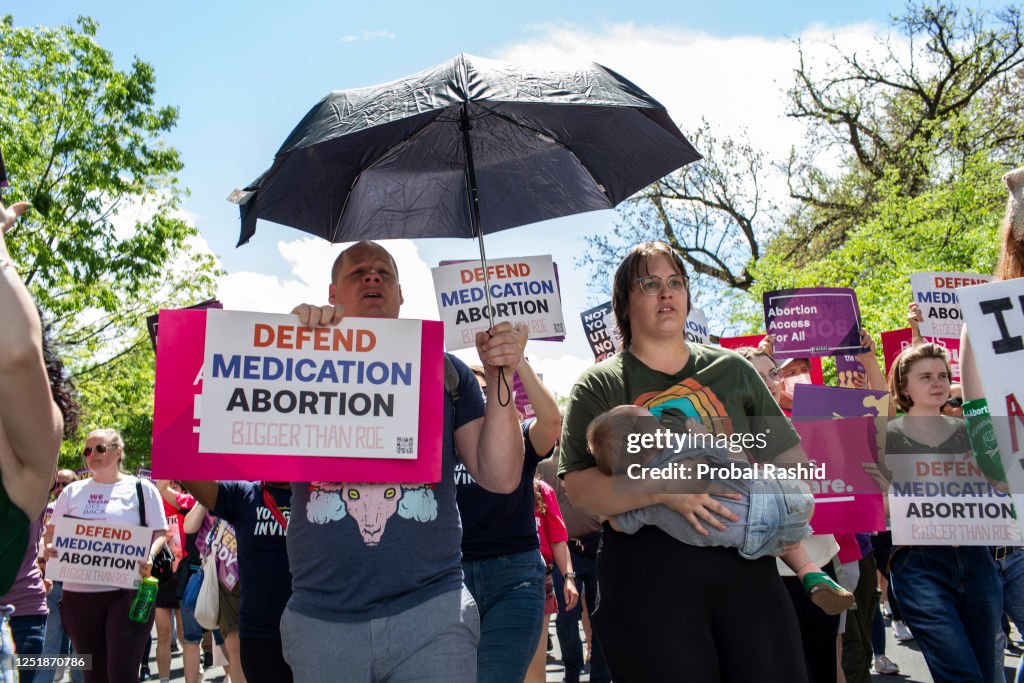 Activists holding abortion rights signs shout slogans while...