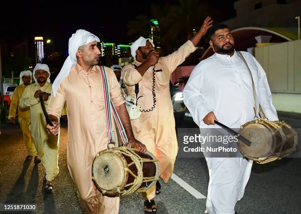 Qatari men play drum and Singing traditional songs to awaken people for sahur meal on a street during Ramadan, in Doha,Qatar on 16 April 2023 . Sahur...
