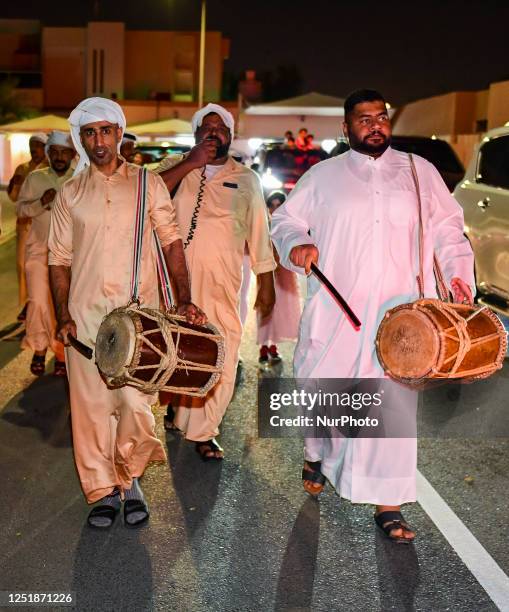 Qatari men play drum and Singing traditional songs to awaken people for sahur meal on a street during Ramadan, in Doha,Qatar on 16 April 2023 . Sahur...