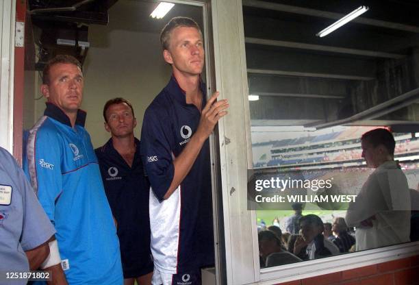 England captain Alec Stewart , Neil Fairbrother and paceman Alan Mullally look out at the bad weather after rain washed out the second one day final...