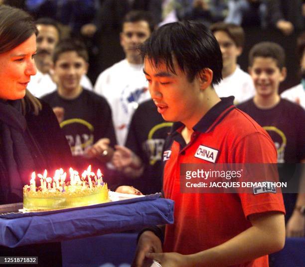 Chinese Liu Guoliang prepares to blow the 23 candles of his birthday cake after being defeated by his compatriot Wang Liqin during the finals of the...