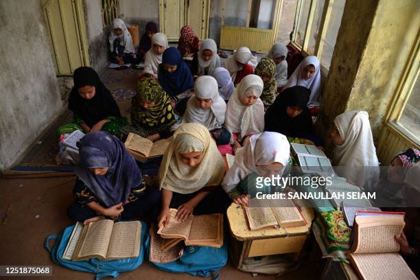 Afghan girls read Koran during the holy fasting month of Ramadan at a madrassa in Kandahar on April 16, 2023.