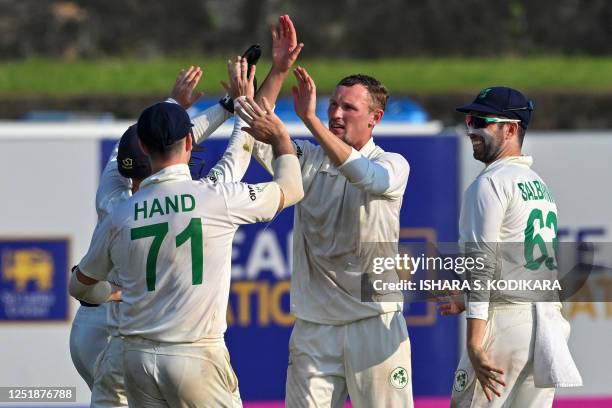 Ireland's Benjamin White celebrates with teammates after taking the wicket of Sri Lanka's Angelo Mathews during the first day of the first cricket...