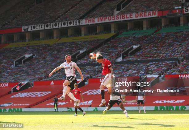 Victor Lindelof of Manchester United heads the ball clear from John Fleck of Sheffield United during the Premier League match between Manchester...