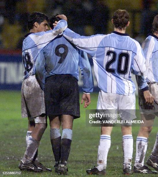 Argentina's soccer Sub 20 players, Facundo Perez Mauro Cetto console Uruguayan player Nathaniel Revetria 22 January 2001 in Cuenca, Ecuador. Los...