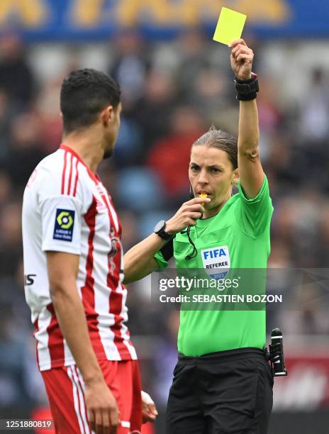 French referee Stephanie Frappart shows a yellow card to Ajaccio's French forward Mounaim El Idrissy during the French L1 football match between RC...