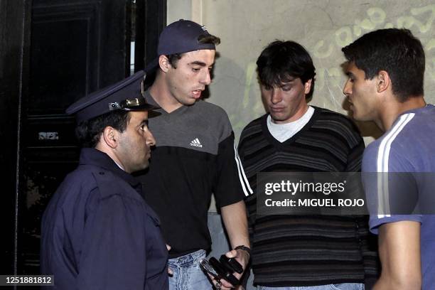 Players for the National Team Alejandro Lembo , Leonardo Romay and Gustavo Munua speak with a police agent, 26 November 2000, in Montevideo,...