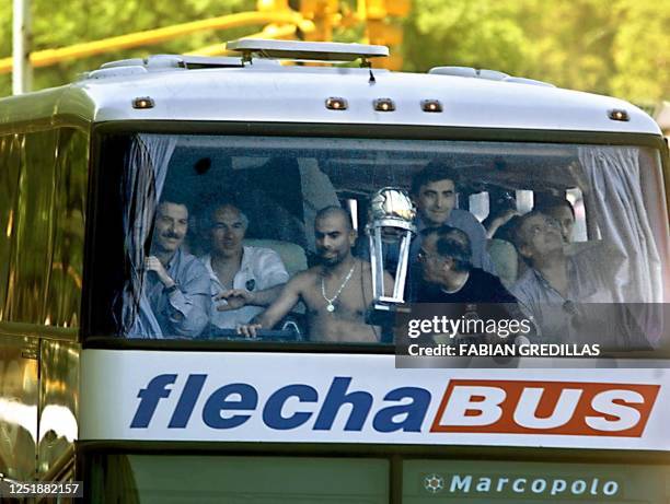 Colombian soccer player Mauricio Serna holds the Intercontinental Cup and is accompanied by coach Carlos Bianchi, and the President of Boca Juniors...