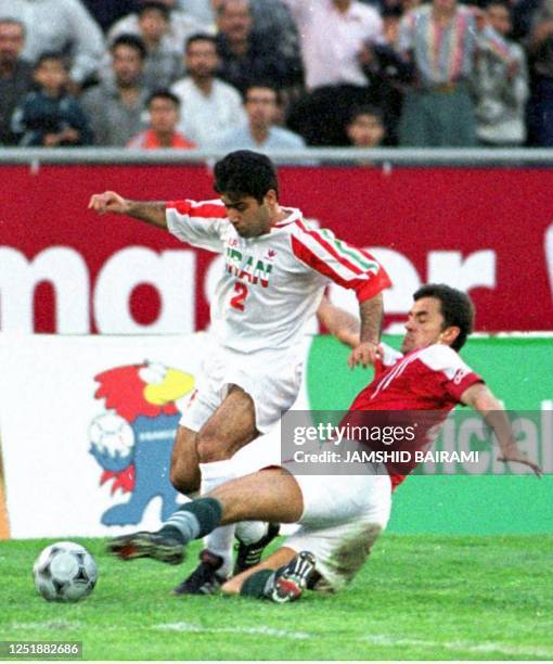 Iranian forward Mehdi Mahdavi-Kia battles against an unidentified member of the Hungarian team 20 April during their match in Terhan. Hungary...