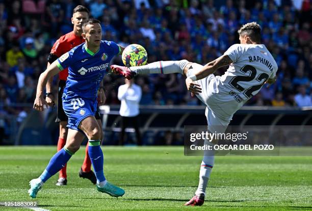 Getafe's Serbian midfielder Nemanja Maksimovic vies with Barcelona's Brazilian forward Raphinha during the Spanish league football match between...