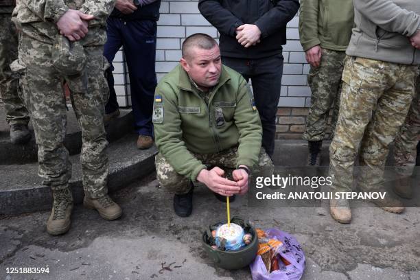 Ukrainian soldier waits next to his baskets with traditional Easter food and wait to be blessed at a church during the Orthodox Easter in the town of...