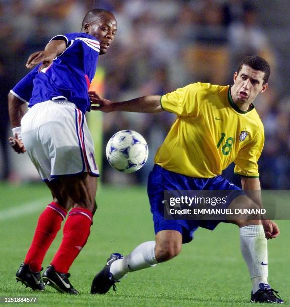 France's Sylvain Wiltord fights for the ball with Brazil's Fabio during the semi-final of the FIFA's Confederations Cup match between France and...