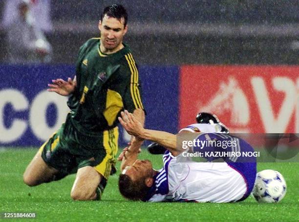 Australia's Tony Vidmar and Japan's Hidetoshi Nakata fall while chasing the ball during their semi-final Confederations Cup match at Yokohama...