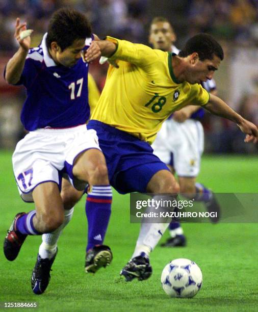 Brazilian player Fabio and Tomokazu Myojin of Japan battle for the ball during their FIFA's Confederations Cup match in Kashima, 100km north of...